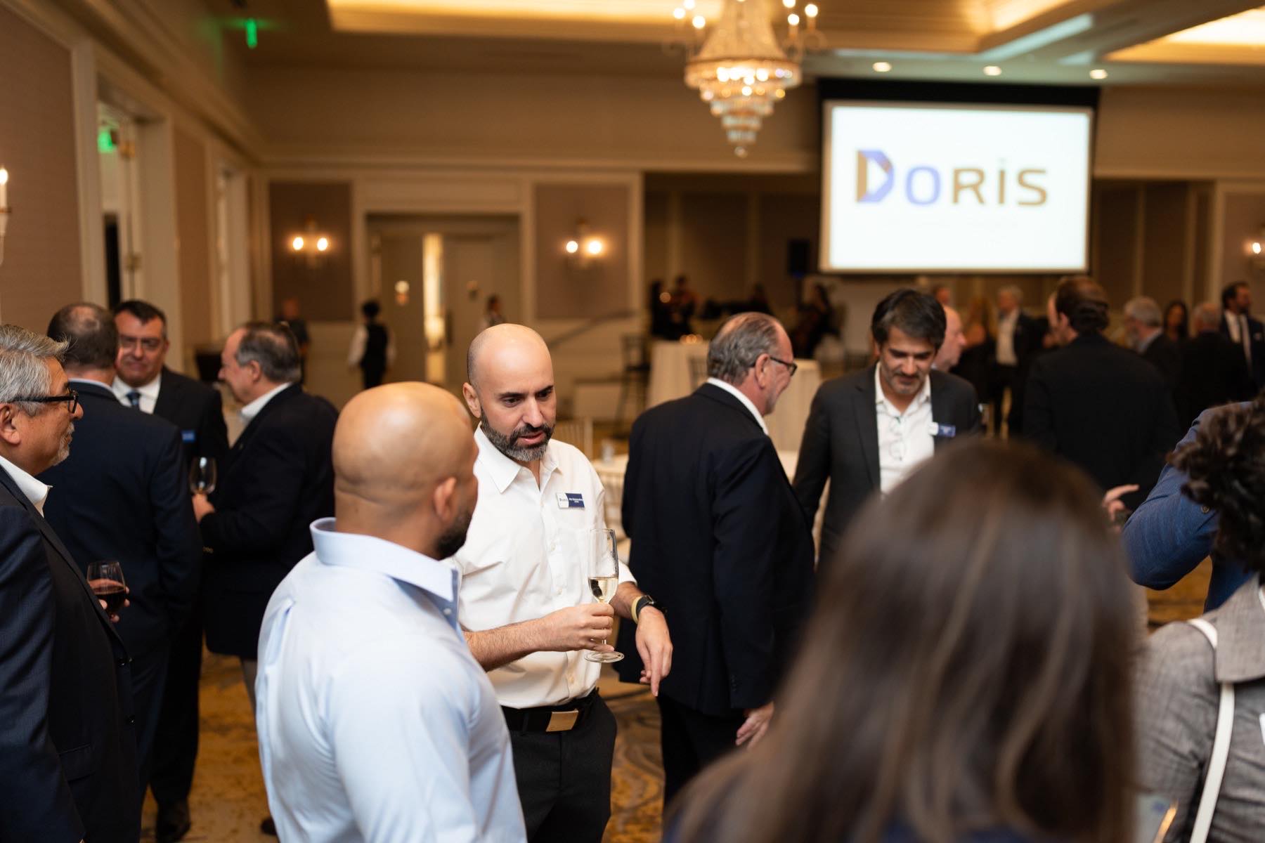 Guests networking before a corporate presentation at a Houston hotel ballroom