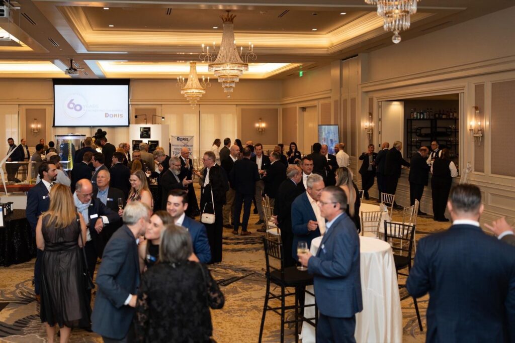 Cocktail reception in a Houston hotel ballroom with standing guests and a bar