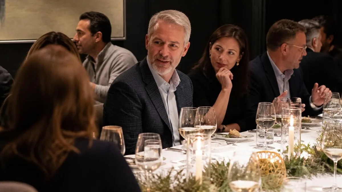 Corporate holiday party ideas for Houston teams: guests at a candlelit seated dinner with winter greenery